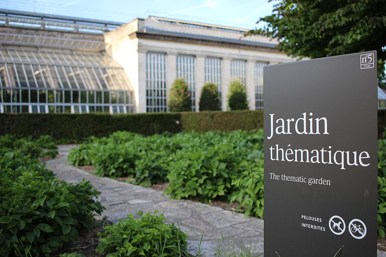 panneau dans un jardin thématique à l'entrée des serres du jardin botanique de Tours (France). A l'arrière, les serres du jardin botanique de Tours.
